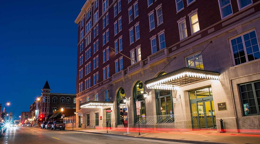 The Hotel Julien at twilight, a historic building with a warmly lit entrance canopy on Dubuque's Main Street
